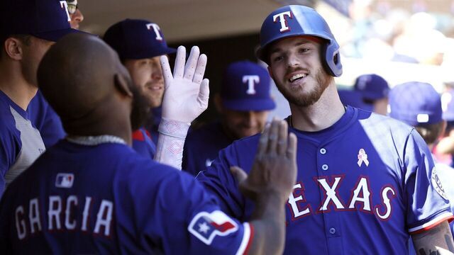 DETROIT, MI - MAY 11: Jonah Heim #28 of the Texas Rangers celebrates with Adolis García #53 in the dugout after hitting a solo home run against the Detroit Tigers during the eighth inning at Comerica Park on May 11, 2025 in Detroit, Michigan.
