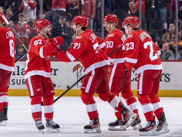 DETROIT, MICHIGAN - NOVEMBER 18: Dylan Larkin #71 of the Detroit Red Wings scores an empty net goal and his 600th NHL point against the Seattle Kraken and celebrates with Alex Debrincat #93, Albert Johansson #20 and Lucas Raymond #23 during the third period at Little Caesars Arena on November 18, 2025 in Detroit, Michigan. Detroit defeated Seattle 4-2.