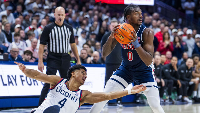 STORRS, CONNECTICUT - NOVEMBER 19: Dwayne Koroma #4 of the Connecticut Huskies goes to the floor defending against Jaden Bradley #0 of the Arizona Wildcats in the first half at Harry A. Gampel Pavilion on November 19, 2025 in Storrs, Connecticut.
