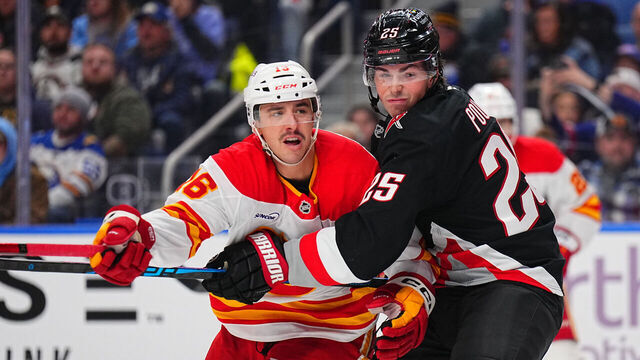 BUFFALO, NEW YORK - NOVEMBER 19: Owen Power #25 of the Buffalo Sabres ties up Morgan Frost #16 of the Calgary Flames in front of Buffalo's net during an NHL game on November 19, 2025 at KeyBank Center in Buffalo, New York.
