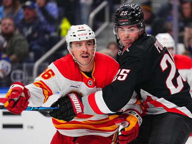 BUFFALO, NEW YORK - NOVEMBER 19: Owen Power #25 of the Buffalo Sabres ties up Morgan Frost #16 of the Calgary Flames in front of Buffalo's net during an NHL game on November 19, 2025 at KeyBank Center in Buffalo, New York.