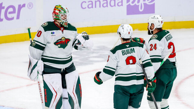 WINNIPEG, CANADA - NOVEMBER 23: Goaltender Jesper Wallstedt #30, Zeev Buium #8 and Zach Bogosian #24 of the Minnesota Wild celebrate a 3-0 shutout victory over the Winnipeg Jets at the Canada Life Centre on November 23, 2025 in Winnipeg, Manitoba, Canada.