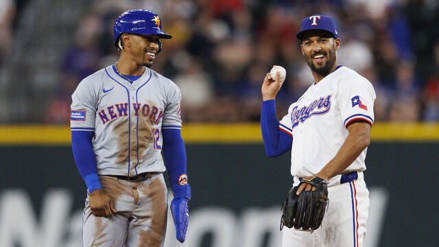ARLINGTON, TX - JUNE 19: Marcus Semien #2 of the Texas Rangers shares a laugh with Francisco Lindor #12 of the New York Mets during a game against the New York Mets at Globe Life Field on June 19, 2024 in Arlington, Texas.