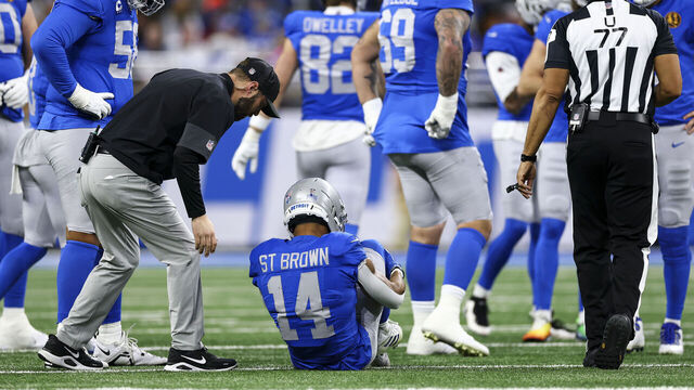 DETROIT, MICHIGAN - NOVEMBER 27: Amon-Ra St. Brown #14 of the Detroit Lions lays on the field after sustaining an injury during the first quarter of an NFL football game against the Green Bay Packers at Ford Field on November 27, 2025 in Detroit, Michigan.