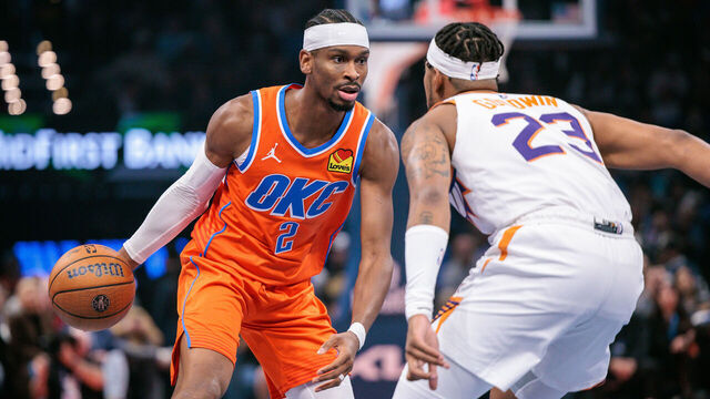 OKLAHOMA CITY, OKLAHOMA - NOVEMBER 28: Shai Gilgeous-Alexander #2 of the Oklahoma City Thunder brings the ball up court around Jordan Goodwin #23 of the Phoenix Suns during the first quarter at Paycom Center on November 28, 2025 in Oklahoma City, Oklahoma.