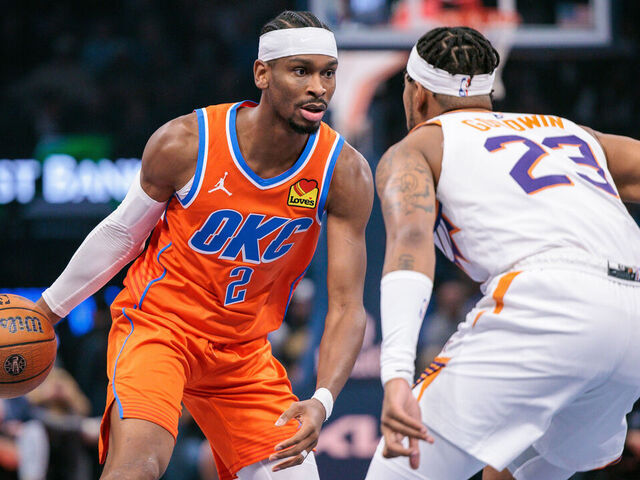 OKLAHOMA CITY, OKLAHOMA - NOVEMBER 28: Shai Gilgeous-Alexander #2 of the Oklahoma City Thunder brings the ball up court around Jordan Goodwin #23 of the Phoenix Suns during the first quarter at Paycom Center on November 28, 2025 in Oklahoma City, Oklahoma.
