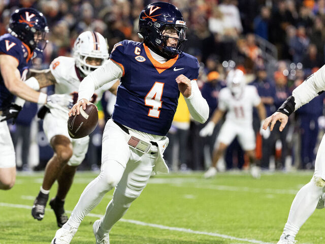 CHARLOTTESVILLE, VIRGINIA - NOVEMBER 29: Chandler Morris #4 of the Virginia Cavaliers scrambles away from Ben Bell #33 of the Virginia Tech Hokies in the first half during a game at Scott Stadium on November 29, 2025 in Charlottesville, Virginia.