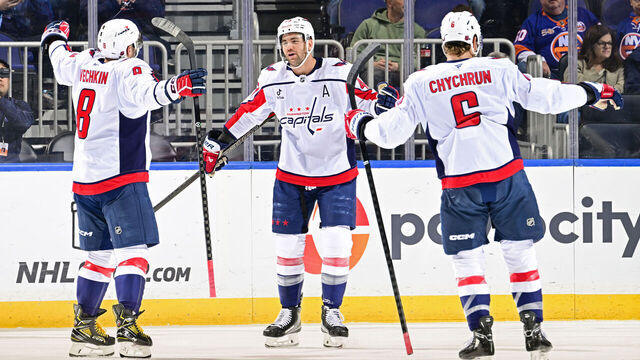 ELMONT, NEW YORK - NOVEMBER 30: Tom Wilson #43 of the Washington Capitals is congratulated by Alex Ovechkin #8 and Jakob Chychrun #6 after scoring a goal against the New York Islanders during the first period at UBS Arena on November 30, 2025 in Elmont, New York.