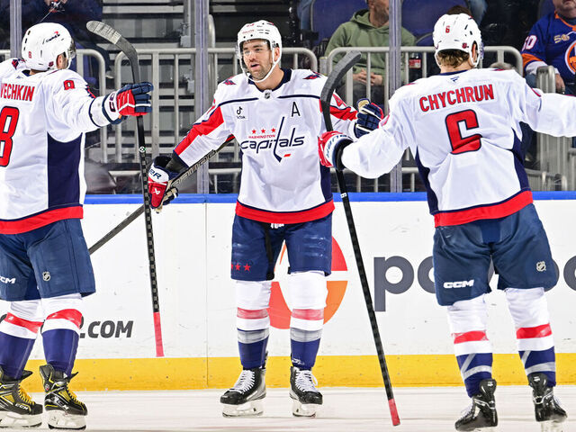 ELMONT, NEW YORK - NOVEMBER 30: Tom Wilson #43 of the Washington Capitals is congratulated by Alex Ovechkin #8 and Jakob Chychrun #6 after scoring a goal against the New York Islanders during the first period at UBS Arena on November 30, 2025 in Elmont, New York.