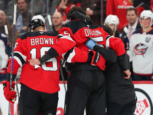 NEWARK, NJ - DECEMBER 01: Brenden Dillon #5 of the New Jersey Devils is helped off the ice after a fight during a game between the Columbus Blue Jackets and New Jersey Devils at Prudential Center on December 1, 2025 in Newark, New Jersey.