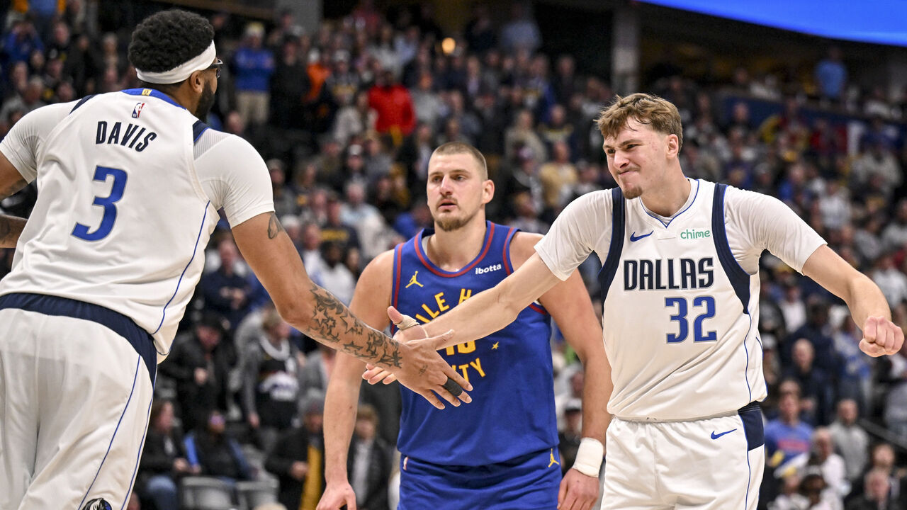 DENVER , CO - DECEMBER 1: Cooper Flagg (32) of the Dallas Mavericks celebrates with Anthony Davis (3) after Davis slammed the ball for two on a put back over Nikola Jokic (15) of the Denver Nuggets during the fourth quarter at Ball Arena in Denver, Colorado on Monday, December 1, 2025.