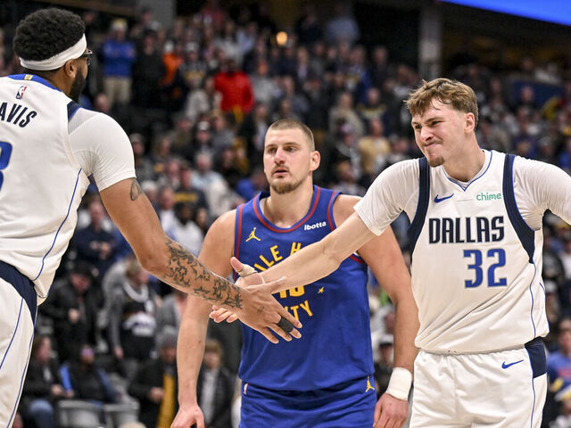 DENVER , CO - DECEMBER 1: Cooper Flagg (32) of the Dallas Mavericks celebrates with Anthony Davis (3) after Davis slammed the ball for two on a put back over Nikola Jokic (15) of the Denver Nuggets during the fourth quarter at Ball Arena in Denver, Colorado on Monday, December 1, 2025.