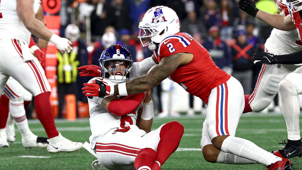 FOXBOROUGH, MASSACHUSETTS - DECEMBER 01: Jaxson Dart #6 of the New York Giants is tackled by Harold Landry III #2 of the New England Patriots during the first quarter of the game at Gillette Stadium on December 01, 2025 in Foxborough, Massachusetts.