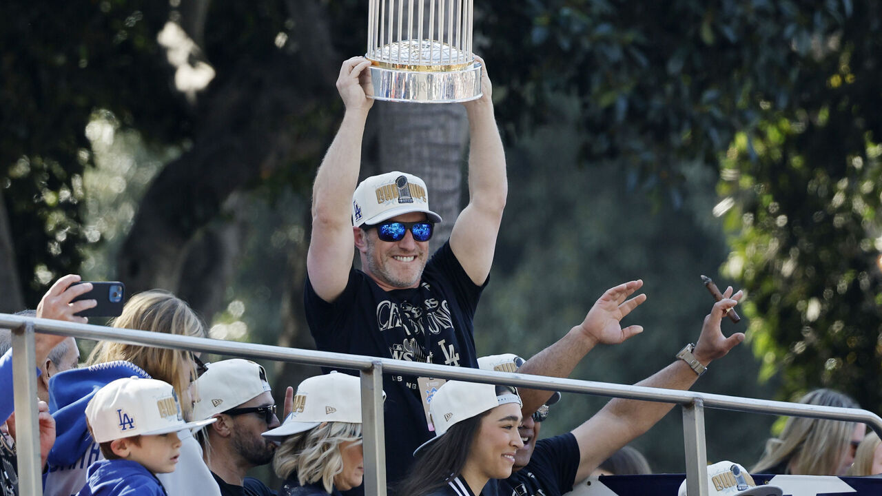 LOS ANGELES, CALIFORNIA - NOVEMBER 01: Josh Byrnes, senior vice president of baseball operations of the Los Angeles Dodgers, celebrates with the Commissioner's Trophy during the 2024 World Series Championship parade on November 01, 2024 in Los Angeles, California.