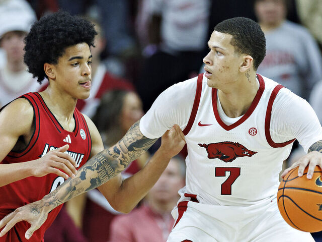 FAYETTEVILLE, ARKANSAS - DECEMBER 03: Trevon Brazile #7 of the Arkansas Razorbacks drives to the basket in the second half against Mikel Brown Jr. #0 of the Louisville Cardinals at Bud Walton Arena on December 03, 2025 in Fayetteville, Arkansas. The Razorbacks defeated the Cardinals 89-80.