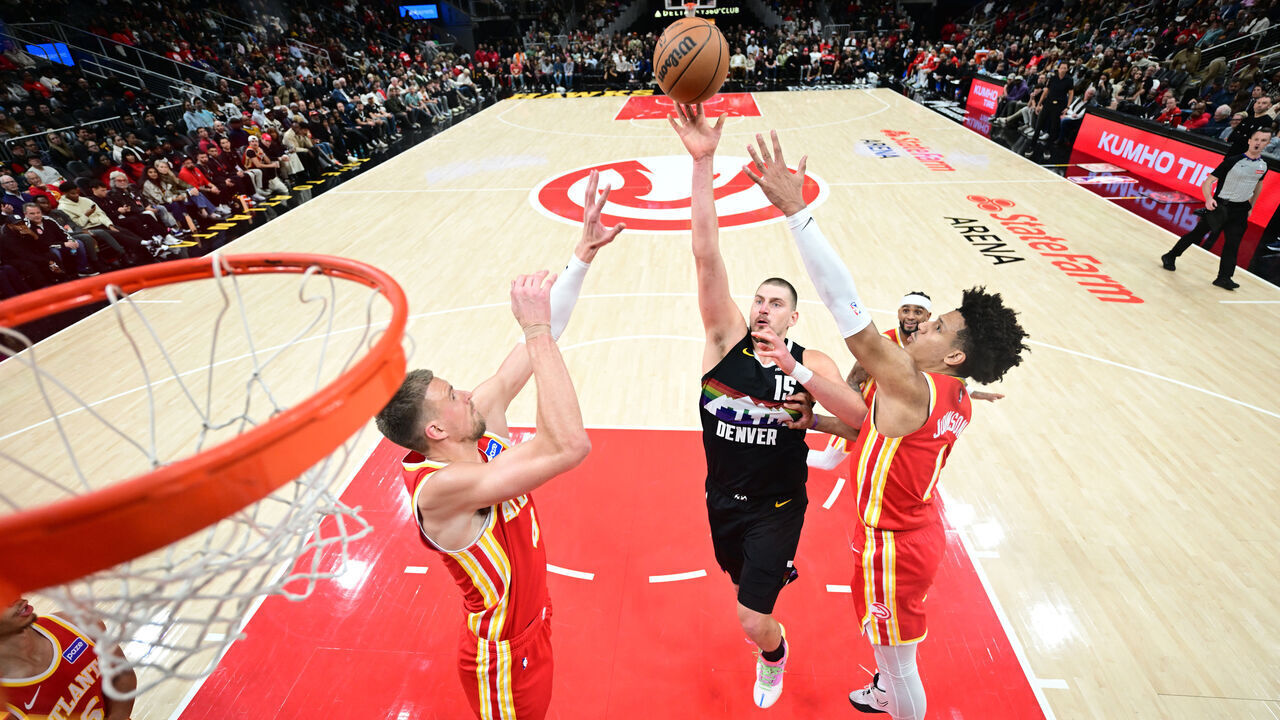 ATLANTA, GA - DECEMBER 5: Nikola Jokic #15 of the Denver Nuggets shoots the ball as Jalen Johnson #1 and Kristaps Porzingis #8 of the Atlanta Hawks plays defense during the game on December 5, 2025 at State Farm Arena in Atlanta, Georgia. NOTE TO USER: User expressly acknowledges and agrees that, by downloading and/or using this Photograph, user is consenting to the terms and conditions of the Getty Images License Agreement. Mandatory Copyright Notice: Copyright 2025 NBAE