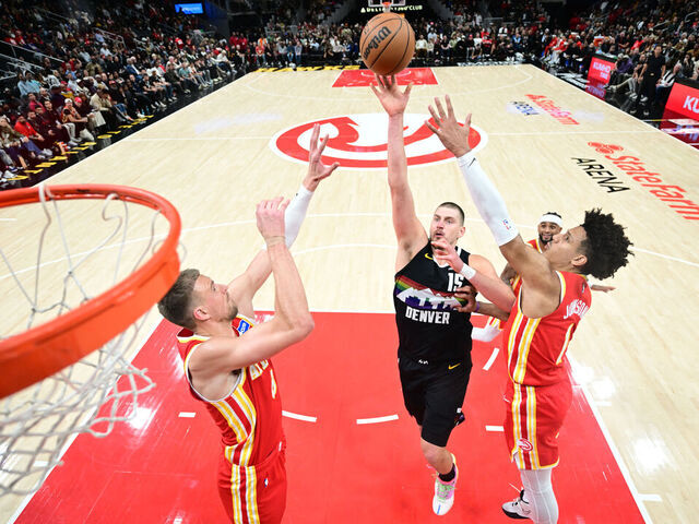 ATLANTA, GA - DECEMBER 5: Nikola Jokic #15 of the Denver Nuggets shoots the ball as Jalen Johnson #1 and Kristaps Porzingis #8 of the Atlanta Hawks plays defense during the game on December 5, 2025 at State Farm Arena in Atlanta, Georgia. NOTE TO USER: User expressly acknowledges and agrees that, by downloading and/or using this Photograph, user is consenting to the terms and conditions of the Getty Images License Agreement. Mandatory Copyright Notice: Copyright 2025 NBAE
