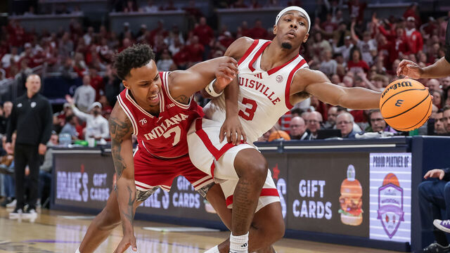 INDIANAPOLIS, INDIANA - DECEMBER 6: Ryan Conwell #3 of the Louisville Cardinals reaches for the ball against Nick Dorn #7 of the Indiana Hoosiers during the first half at Gainbridge Fieldhouse on December 6, 2025 in Indianapolis, Indiana.