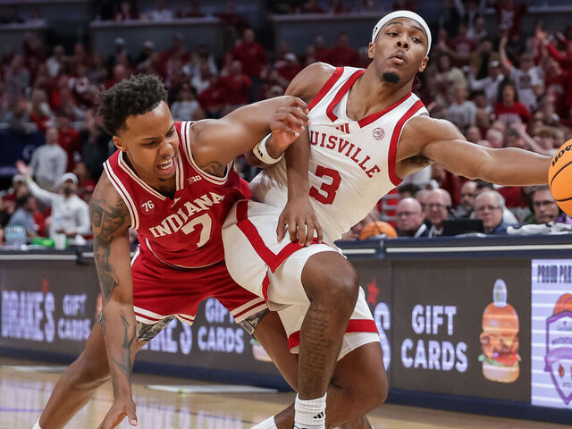 INDIANAPOLIS, INDIANA - DECEMBER 6: Ryan Conwell #3 of the Louisville Cardinals reaches for the ball against Nick Dorn #7 of the Indiana Hoosiers during the first half at Gainbridge Fieldhouse on December 6, 2025 in Indianapolis, Indiana.