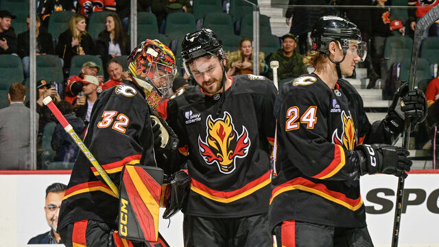 CALGARY, ALBERTA - DECEMBER 06: Dustin Wolf #32 and Rasmus Andersson #4 of the Calgary Flames celebrate a win against the Utah Mammoth at the Scotiabank Saddledome on December 06, 2025 in Calgary, Alberta.