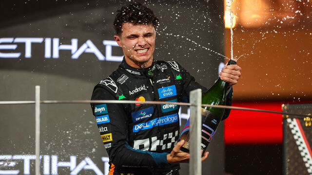 ABU DHABI, UNITED ARAB EMIRATES - DECEMBER 7: Lando Norris of Great Britain and McLaren sprays Champagne to celebrate his world championship on the podium during the F1 Grand Prix of Abu Dhabi at Yas Marina Circuit on December 7, 2025 in Abu Dhabi, United Arab Emirates.
