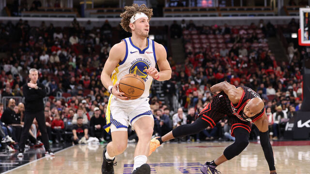 CHICAGO, ILLINOIS - DECEMBER 7: Brandin Podziemski #2 of the Golden State Warriors dribbles past Jevon Carter #5 of the Chicago Bulls during the second half at the United Center on December 7, 2025 in Chicago, Illinois.