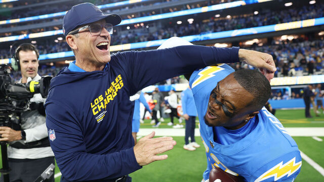 INGLEWOOD, CALIFORNIA - DECEMBER 08: Head coach Jim Harbaugh celebrates with Tony Jefferson #23 of the Los Angeles Chargers after Jefferson intercepted a pass during overtime to beat the Philadelphia Eagles 22-19 at SoFi Stadium on December 08, 2025 in Inglewood, California.