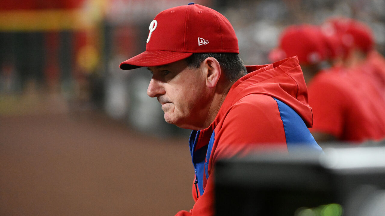 PHOENIX, ARIZONA - SEPTEMBER 20: Manager Rob Thomson #49 of the Philadelphia Phillies looks on from the dugout against the Arizona Diamondbacks at Chase Field on September 20, 2025 in Phoenix, Arizona.