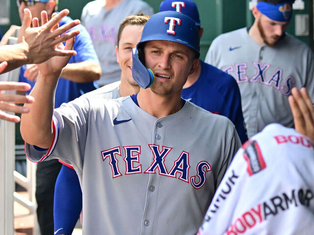 KANSAS CITY, MO - AUG 21: Texas Rangers shortstop Corey Seager (5) is congratulated by teammates after scoring during a MLB game between the Texas Rangers and the Kansas City Royals on August 21, 2025, at Kauffman Stadium in Kansas City, MO.