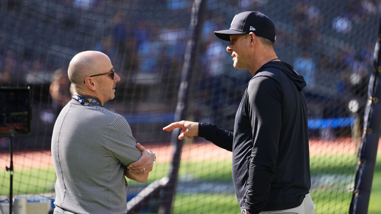 TORONTO, ONTARIO - OCTOBER 05: (L-R) Brian Cashman, Senior Vice President and General Manager of the New York Yankees, and Aaron Boone #17 of the New York Yankees speak before game two of the American League Division Series against the Toronto Blue Jays at Rogers Centre on October 05, 2025 in Toronto, Ontario.
