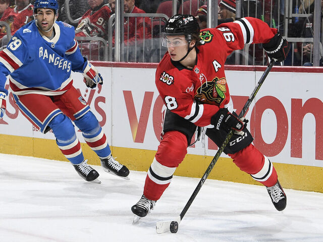 CHICAGO, ILLINOIS - DECEMBER 10: Connor Bedard #98 of the Chicago Blackhawks grabs the puck ahead of \r29#2 of the New York Rangers in the first period at the United Center on December 10, 2025 in Chicago, Illinois.