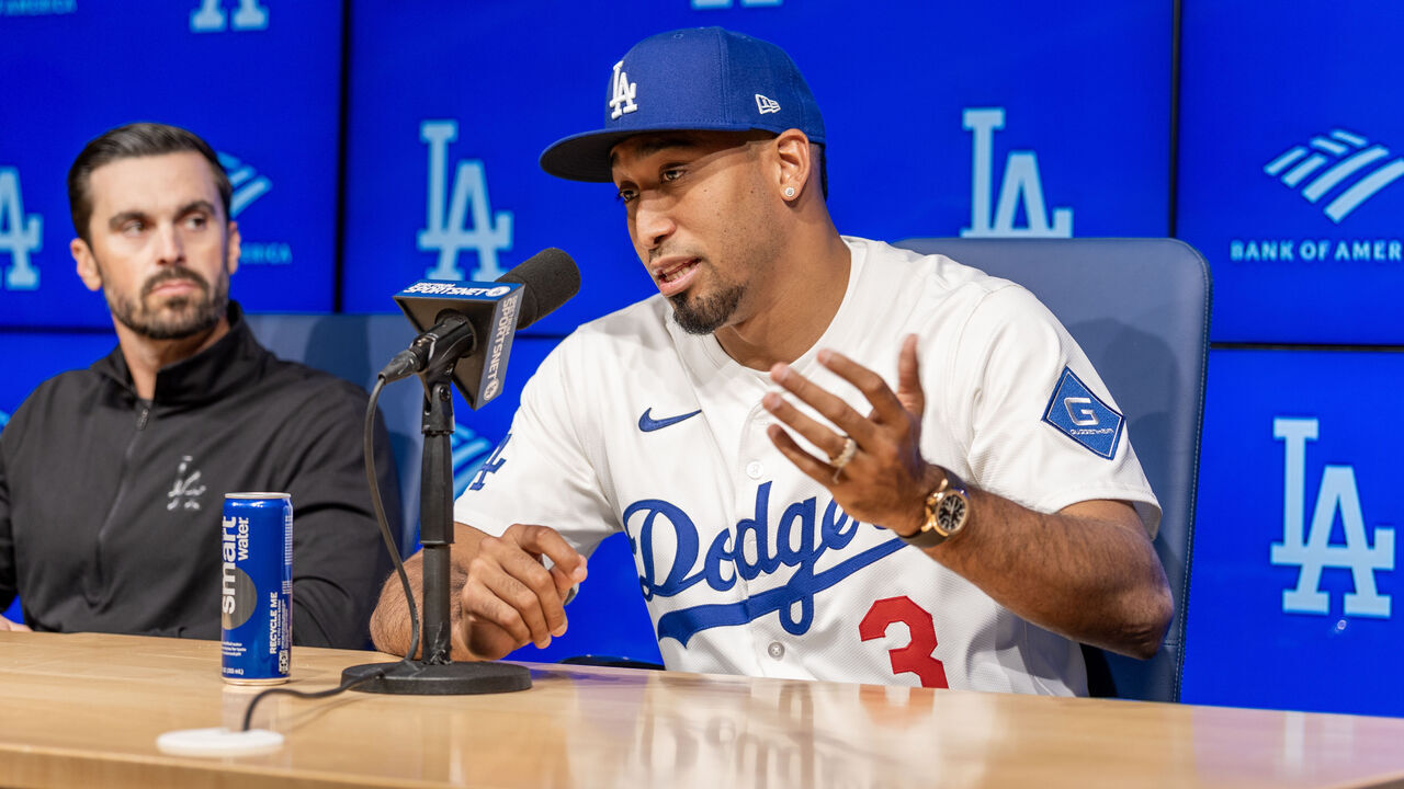 Los Angeles, CA December 12: Dodgers general manager Brandon Gomes, left, listens to star closer Edwin Díaz speak as he shows off his new uniform during a press conference announcing his three-year, $69 million contract at Dodger Stadium on Friday, Dec. 12, 2025. Díaz was considered the top reliever on the market. (Allen J. Schaben / Los Angeles Times via Getty Images)