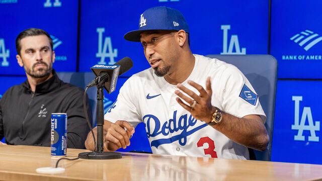 Los Angeles, CA December 12: Dodgers general manager Brandon Gomes, left, listens to star closer Edwin Díaz speak as he shows off his new uniform during a press conference announcing his three-year, $69 million contract at Dodger Stadium on Friday, Dec. 12, 2025. Díaz was considered the top reliever on the market. (Allen J. Schaben / Los Angeles Times via Getty Images)