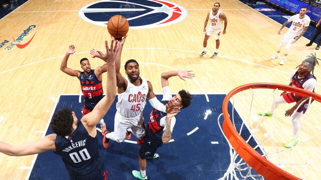 WASHINGTON, DC - DECEMBER 12: Donovan Mitchell #45 of the Cleveland Cavaliers shoots the ball as Will Riley #27 and Tristan Vukcevic #00 of the Washington Wizards plays defense during the game on December 12, 2025 at Capital One Arena in Washington, DC. Mandatory Copyright Notice: Copyright 2025 NBAE