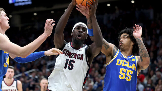 SEATTLE, WASHINGTON - DECEMBER 13: Graham Ike #15 of the Gonzaga Bulldogs drives to the hoop against Tyler Bilodeau #34 and Skyy Clark #55 of the UCLA Bruins during the first half at Climate Pledge Arena on December 13, 2025 in Seattle, Washington.