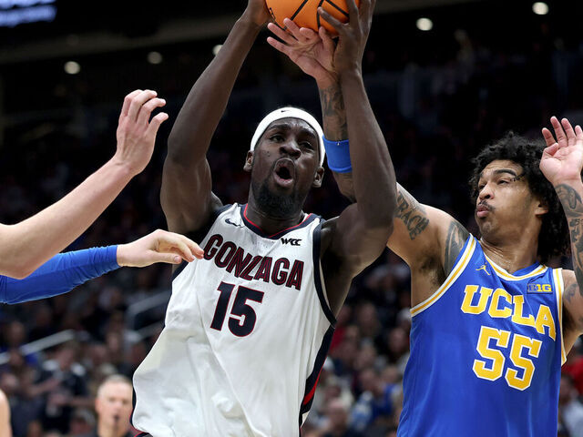 SEATTLE, WASHINGTON - DECEMBER 13: Graham Ike #15 of the Gonzaga Bulldogs drives to the hoop against Tyler Bilodeau #34 and Skyy Clark #55 of the UCLA Bruins during the first half at Climate Pledge Arena on December 13, 2025 in Seattle, Washington.