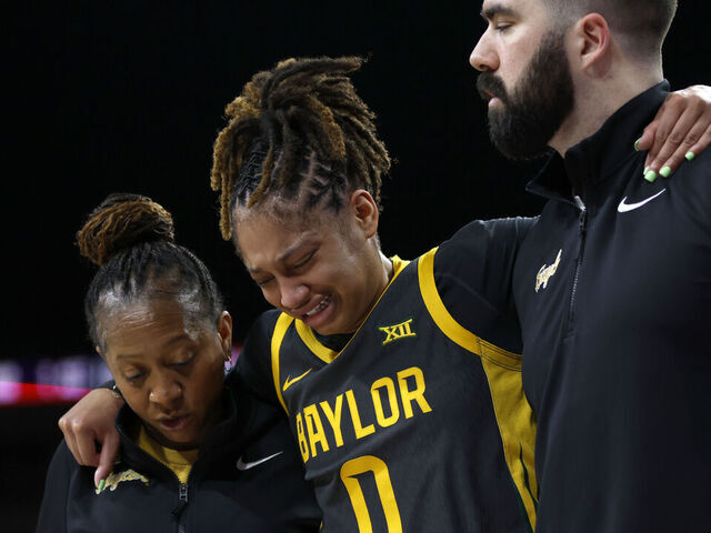 FORT WORTH, TEXAS - DECEMBER 14: Taliah Scott #0 of the Baylor Bears is helped off the floor during the first half against the Texas Longhorns at Dickies Arena on December 14, 2025 in Fort Worth, Texas.
