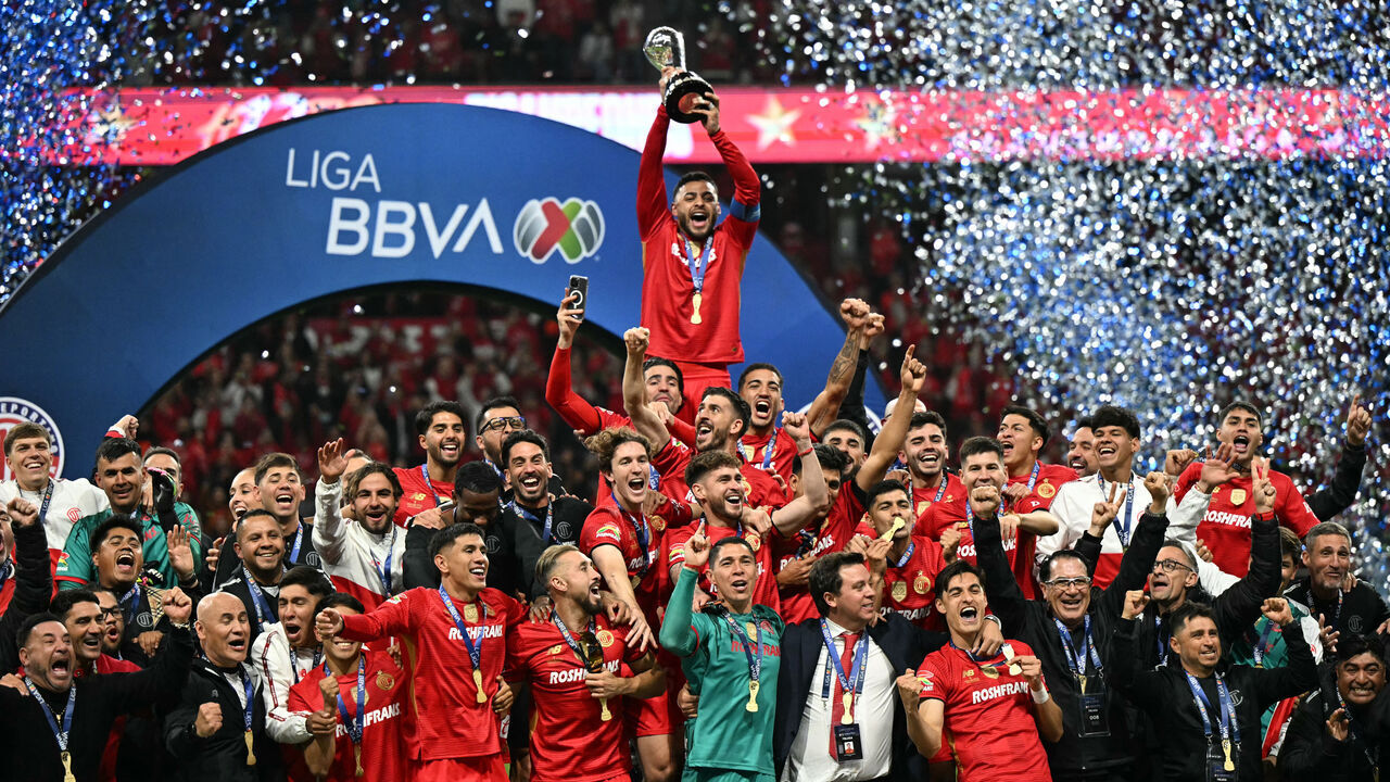 Toluca's forward #09 Alexis Vega lifts the trophy next to teammates after winning the Liga MX Apertura final second leg football match between Toluca and Tigres at the Nemesio Diez stadium in Toluca, Mexico on December 14, 2025.