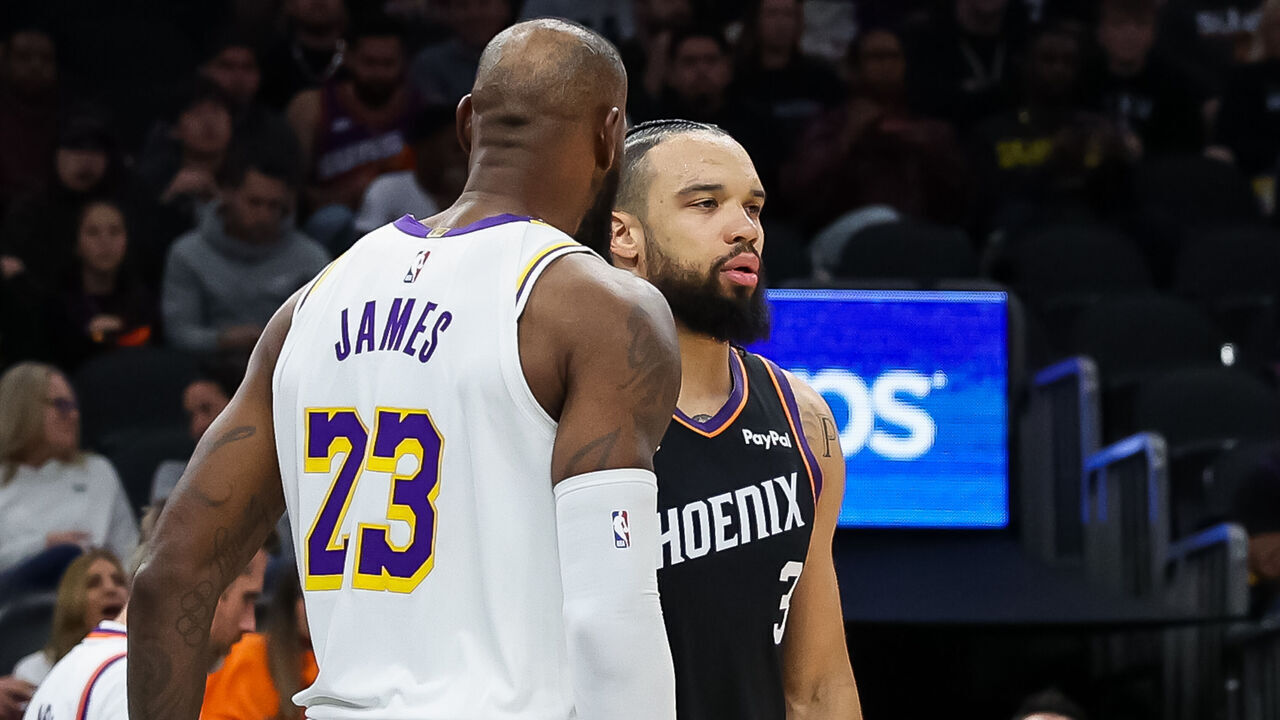 PHOENIX, ARIZONA - DECEMBER 14: Lebron James #23 of the Los Angeles Lakers and Dillon Brooks #3 of the Phoenix Suns get together after a play during the second half of a game at Mortgage Matchup Center on December 14, 2025 in Phoenix, Arizona.