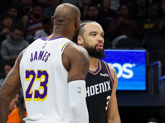 PHOENIX, ARIZONA - DECEMBER 14: Lebron James #23 of the Los Angeles Lakers and Dillon Brooks #3 of the Phoenix Suns get together after a play during the second half of a game at Mortgage Matchup Center on December 14, 2025 in Phoenix, Arizona.