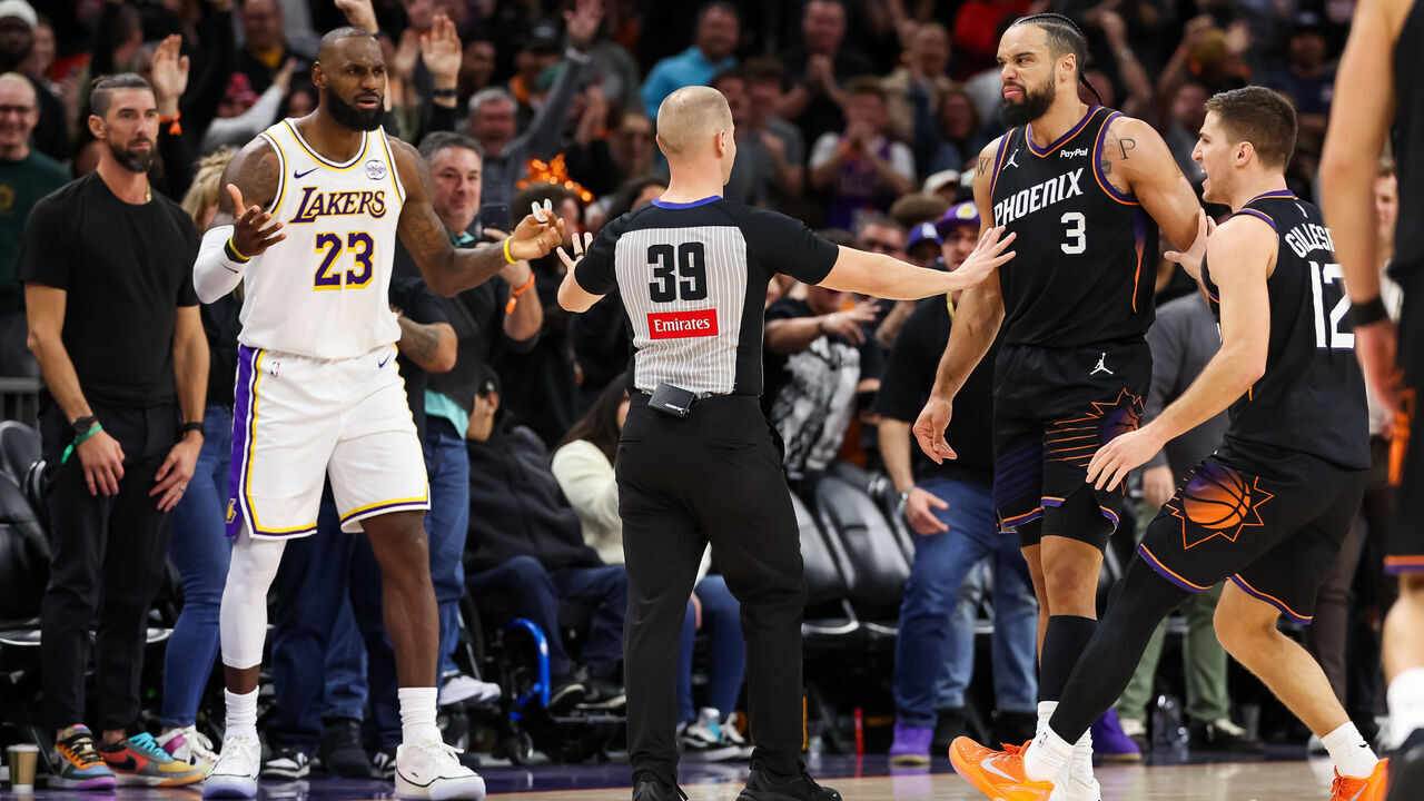 PHOENIX, ARIZONA - DECEMBER 14: An official comes between Lebron James #23 of the Los Angeles Lakers and Dillon Brooks #3 of the Phoenix Suns during the second half of a game at Mortgage Matchup Center on December 14, 2025 in Phoenix, Arizona.
