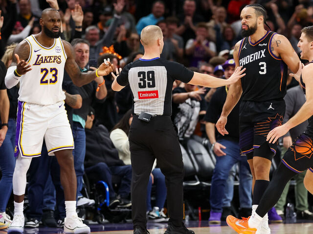 PHOENIX, ARIZONA - DECEMBER 14: An official comes between Lebron James #23 of the Los Angeles Lakers and Dillon Brooks #3 of the Phoenix Suns during the second half of a game at Mortgage Matchup Center on December 14, 2025 in Phoenix, Arizona.