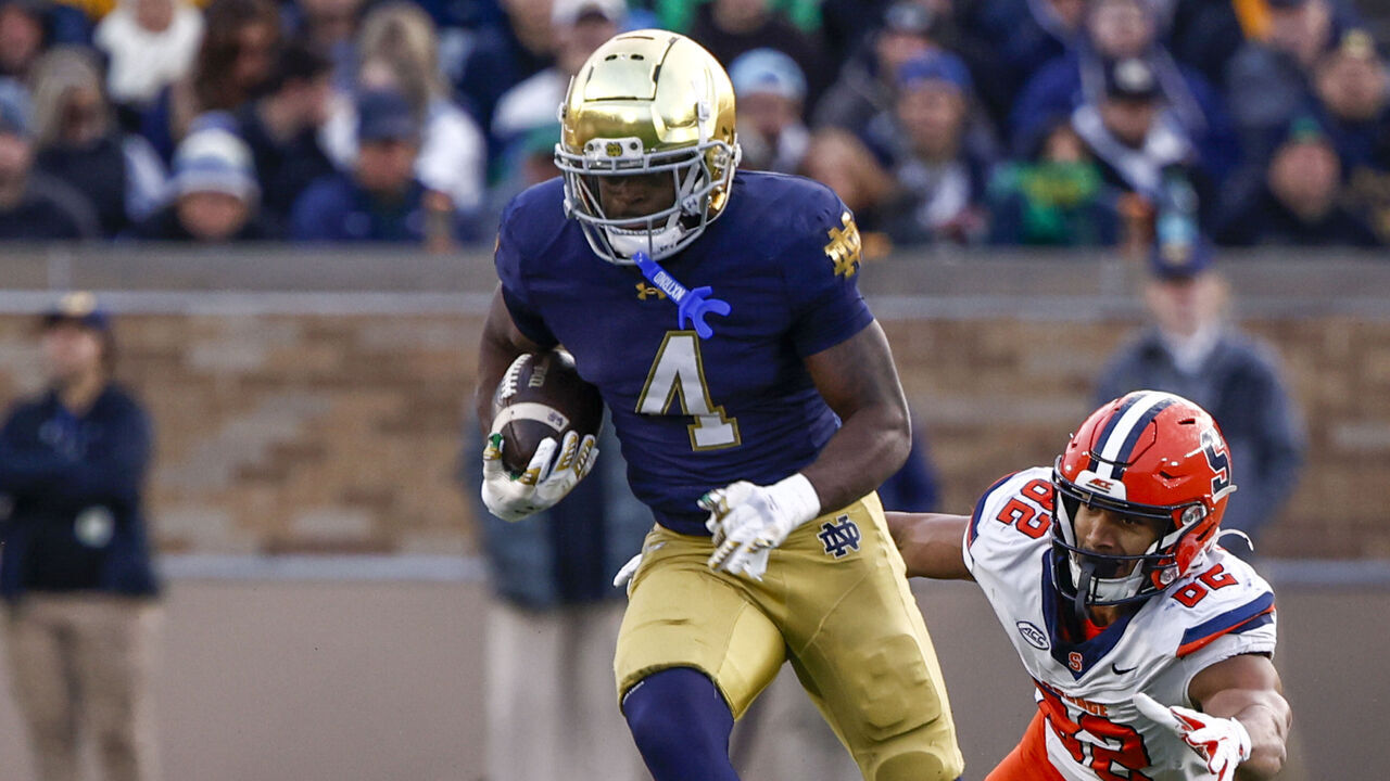 SOUTH BEND, IN - NOVEMBER 22: Jeremiyah Love #4 of the University of Notre Dame runs with the ball past the diving tackle attempt of Jamie Tremble #82 of Syracuse University during a game between Syracuse University and University of Notre Dame at Notre Dame Stadium on November 22, 2025 in South Bend, Indiana.
