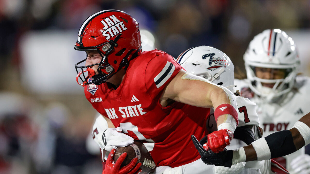 MONTGOMERY, ALABAMA - DECEMBER 16: Brock Rechsteiner #3 of the Jacksonville State Gamecocks is tackled by Jordan Stringer #7 of the Troy Trojans in the first half during the IS4S Salute To Veterans Bowl at Cramton Bowl on December 16, 2025 in Montgomery, Alabama.