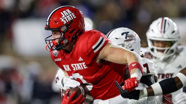 MONTGOMERY, ALABAMA - DECEMBER 16: Brock Rechsteiner #3 of the Jacksonville State Gamecocks is tackled by Jordan Stringer #7 of the Troy Trojans in the first half during the IS4S Salute To Veterans Bowl at Cramton Bowl on December 16, 2025 in Montgomery, Alabama.