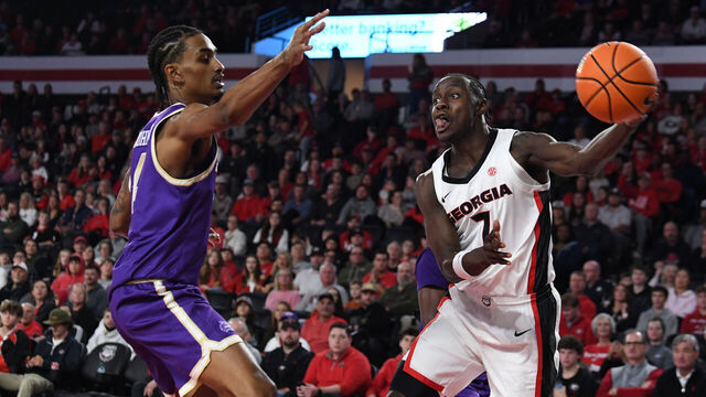 ATHENS, GA - DECEMBER 18: Guard Justin Bailey #7 of the Georgia Bulldogs passes the ball as guard Justin Johnson #4 of the Western Carolina Catamounts defends during the college basketball game between the Western Carolina Catamounts and the Georgia Bulldogs on December 18, 2025, at Stegeman Coliseum in Athens, GA.