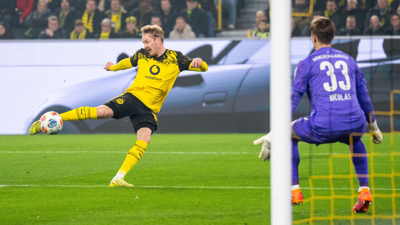 DORTMUND, GERMANY - DECEMBER 19: Julian Brandt of Borussia Dortmund scores the opening goal past goalkeeper Moritz Nicolas of Borussia Monchengladbach during the Bundesliga match between Borussia Dortmund and Borussia M+?nchengladbach at Signal Iduna Park on December 19, 2025 in Dortmund, Germany.