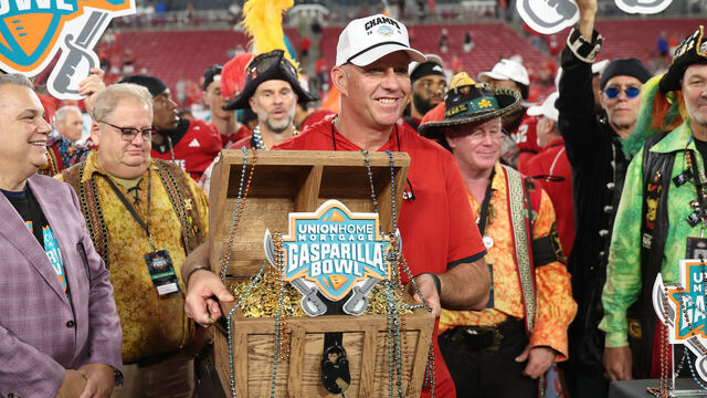 TAMPA, FL - DECEMBER 19: NC State Wolfpack head coach Dave Doeren holds the winner's trophy following the Gasparilla Bowl between the Memphis Tigers and the NC State Wolfpack on Friday, December 19, 2025 at Raymond James Stadium in Tampa, FL