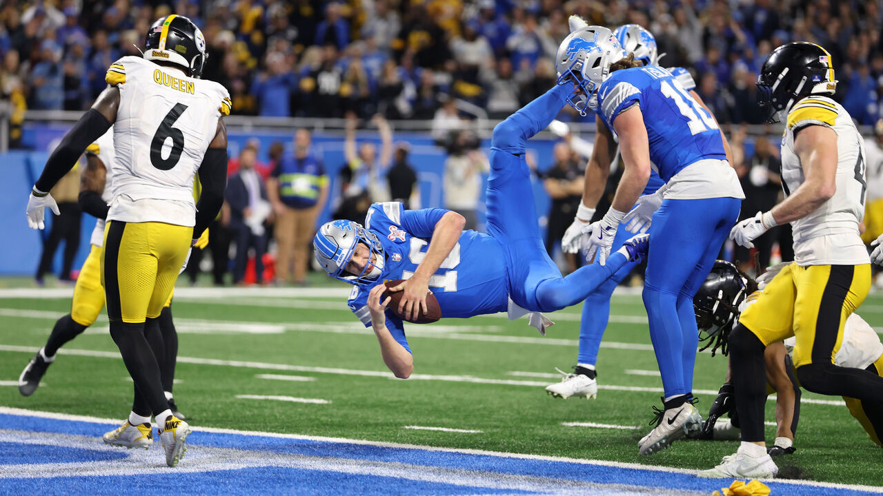 DETROIT, MICHIGAN - DECEMBER 21: Jared Goff #16 of the Detroit Lions leaps into the end zone to score a fourth quarter touchdown against the Pittsburgh Steelers at Ford Field on December 21, 2025 in Detroit, Michigan. The touchdown was nullified due to offensive pass interference by Amon-Ra St. Brown #14 of the Detroit Lions.