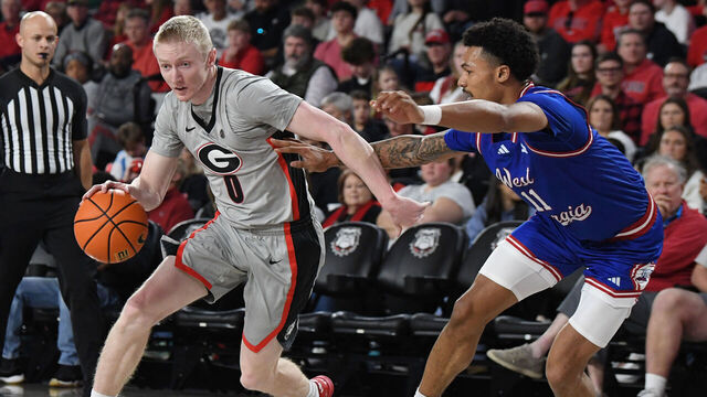 ATHENS, GA - DECEMBER 22: Guard Blue Cain #0 of the Georgia Bulldogs drives to the basket as forward Kolten Griffin #11 of the West Georgia Wolves defends during the college basketball game between the West Georgia Wolves and the Georgia Bulldogs on December 22, 2025, at Stegeman Coliseum in Athens, GA.